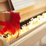 Gift Box And Fairy Lights On Piano Keys, Space For Text. Christm