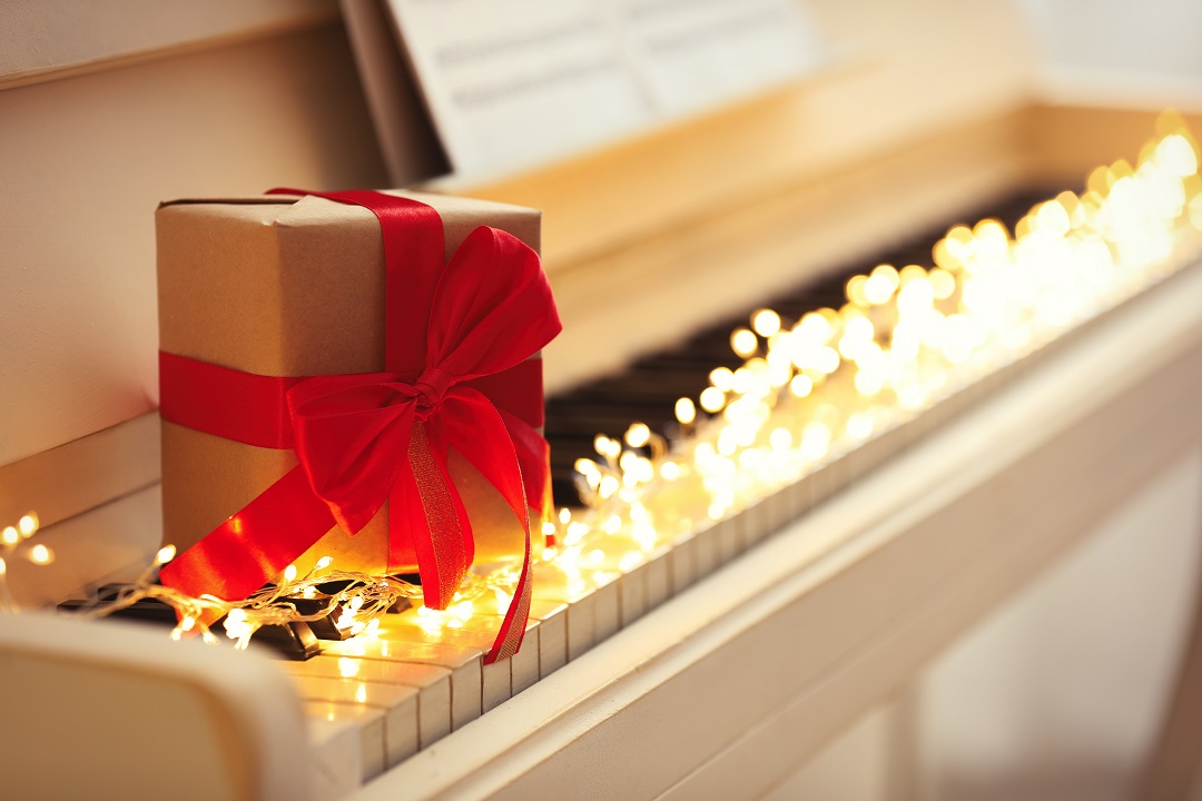Gift Box And Fairy Lights On Piano Keys, Space For Text. Christm